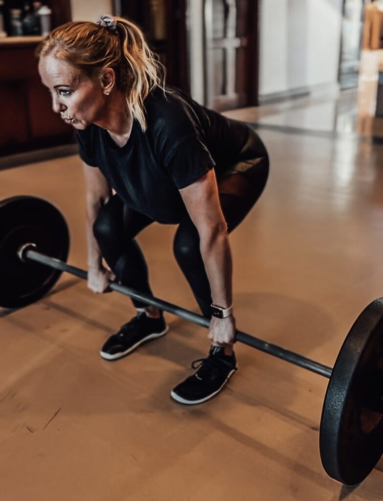 Woman Over 40 weight training-performing a deadlift.