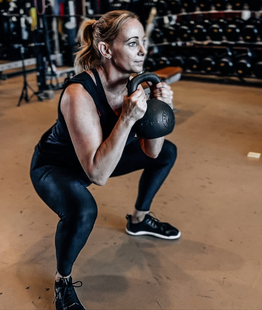 Woman Over 40 weight training-performing a kettlebell goblet squat